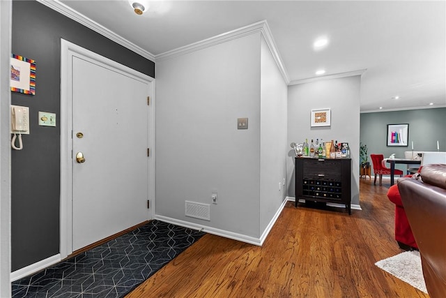 entryway with crown molding, wood finished floors, baseboards, and recessed lighting