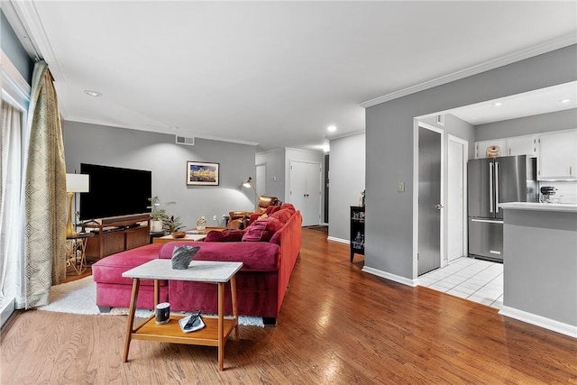 living area featuring crown molding, light wood finished floors, baseboards, and recessed lighting