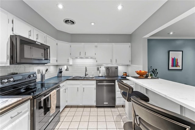 kitchen featuring stainless steel appliances, a sink, backsplash, white cabinets, and recessed lighting
