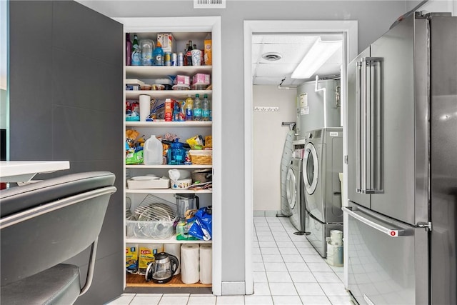 storage area featuring independent washer and dryer and electric water heater