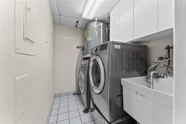 laundry room featuring electric water heater, cabinet space, washer and dryer, and light tile patterned flooring