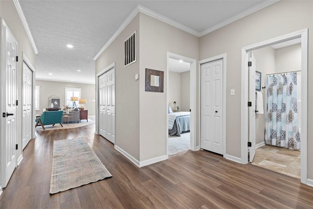 corridor featuring wood finished floors, crown molding, recessed lighting, and baseboards