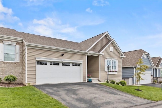 view of front of house with asphalt driveway, an attached garage, and a front yard