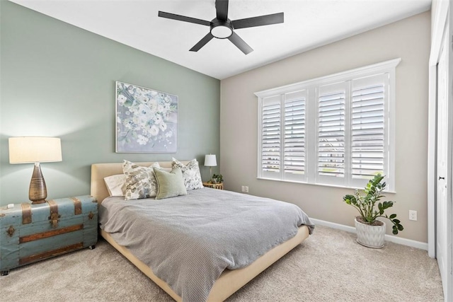 carpeted bedroom featuring baseboards and a ceiling fan