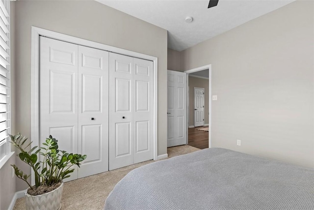 bedroom featuring carpet, a closet, a ceiling fan, and baseboards