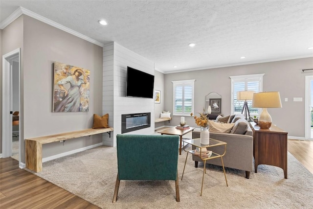 living area with wood finished floors, recessed lighting, a fireplace, crown molding, and baseboards