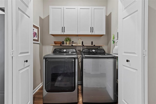 clothes washing area with cabinet space, separate washer and dryer, and wood finished floors