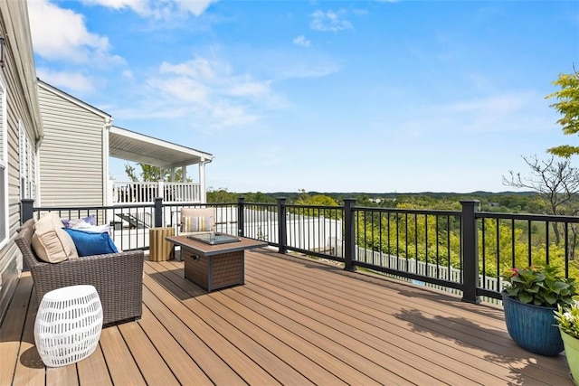 wooden terrace with a water view and a fire pit