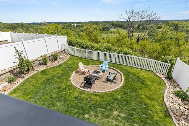 view of yard featuring an outdoor fire pit and a forest view