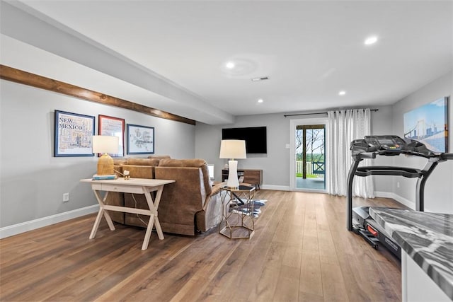 living area featuring wood-type flooring, baseboards, and recessed lighting