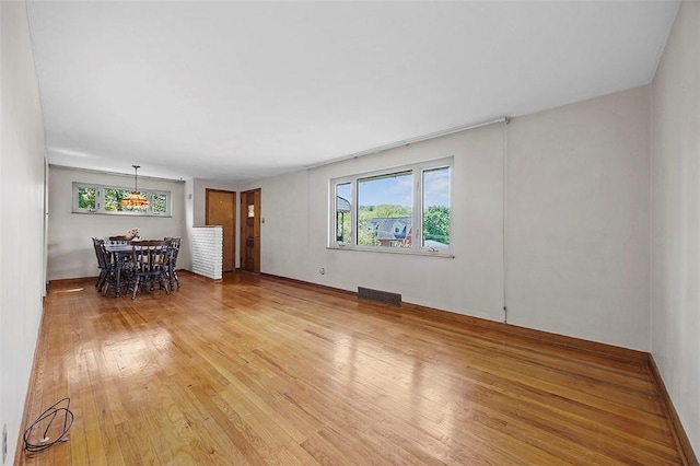 unfurnished living room featuring light wood-type flooring and baseboards