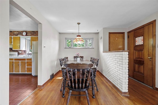 dining space with baseboards and wood finished floors
