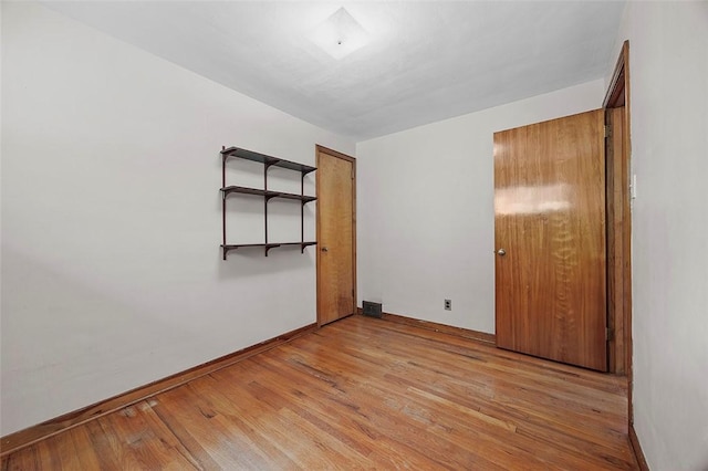 unfurnished bedroom with baseboards and light wood-style flooring