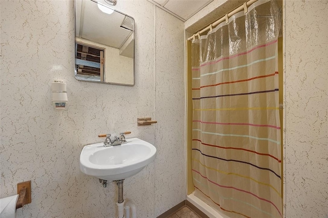 full bath featuring curtained shower and a sink