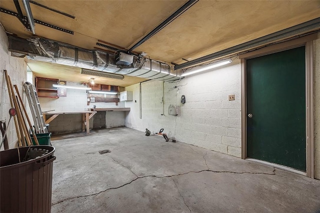 basement featuring concrete block wall and a workshop area