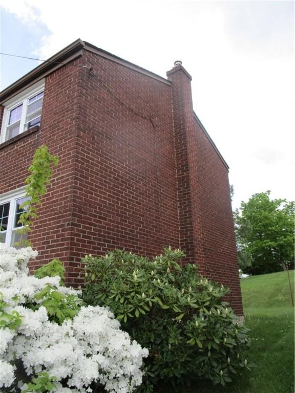 view of side of property with brick siding and a chimney