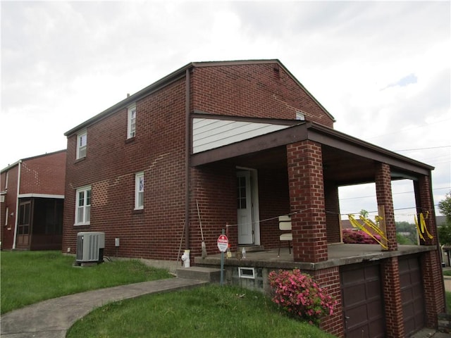 view of property exterior with central AC, brick siding, a lawn, a garage, and covered porch