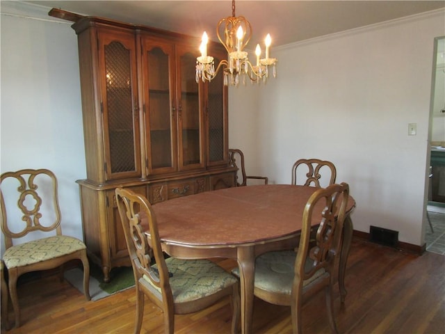 dining area featuring ornamental molding, wood finished floors, a chandelier, and baseboards