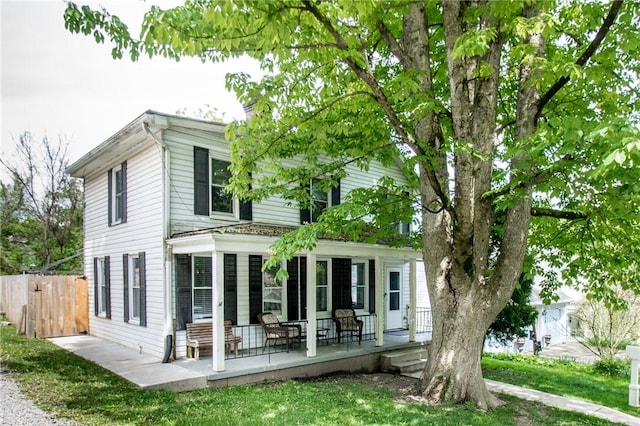 back of property featuring fence and covered porch