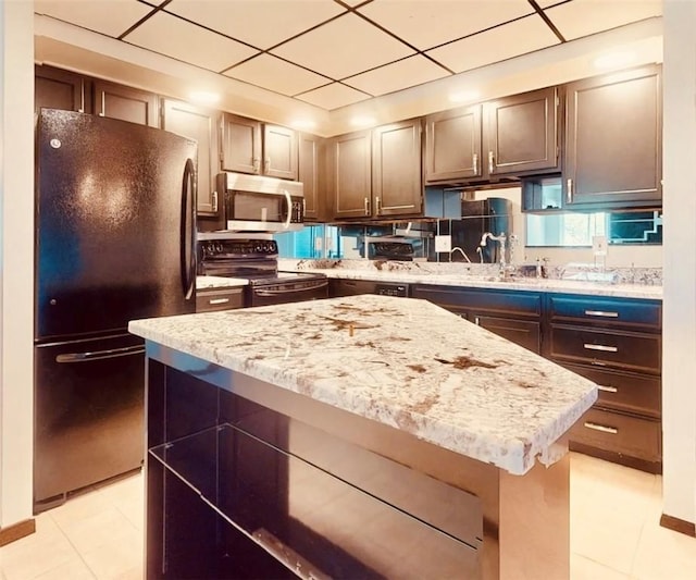 5600 Munhall Rd Unit 403, Squirrel Hill, PA 15217 - kitchen with black appliances, light tile patterned floors, light stone counters, a center island, and a paneled ceiling