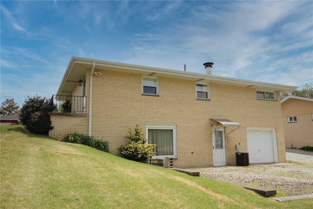 back of house with brick siding, an attached garage, and a lawn