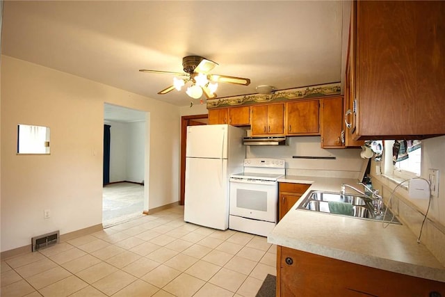 kitchen with white appliances, a sink, brown cabinets, ceiling fan, and light countertops