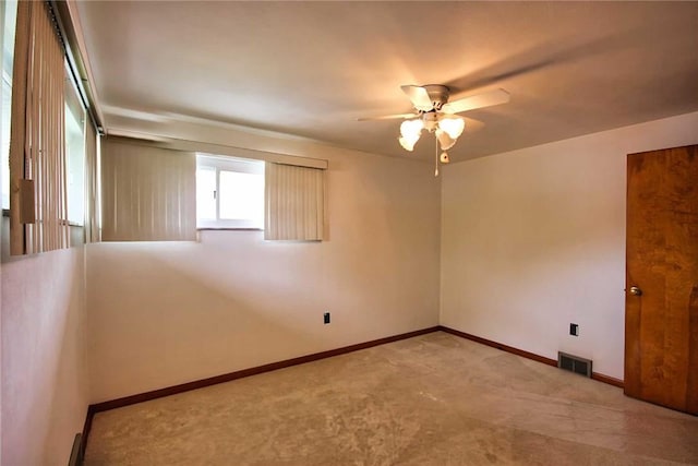 carpeted empty room with a ceiling fan and baseboards