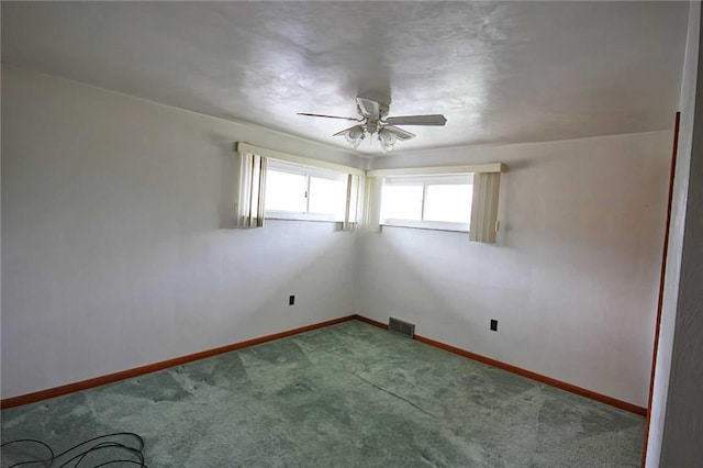 empty room with a ceiling fan, carpet, and baseboards