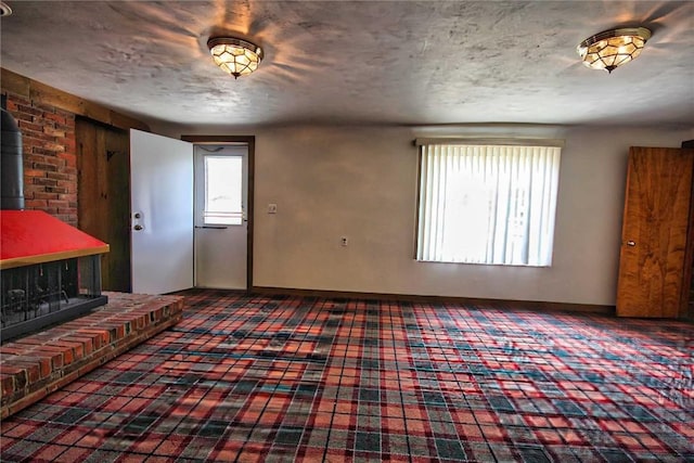 foyer entrance with a wood stove, healthy amount of natural light, and carpet floors