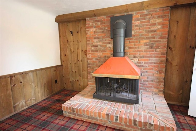 detailed view of wood walls, a wood stove, and wainscoting