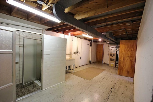 unfinished basement with heating unit and wood finished floors
