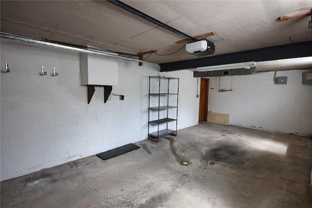 garage with a garage door opener and concrete block wall