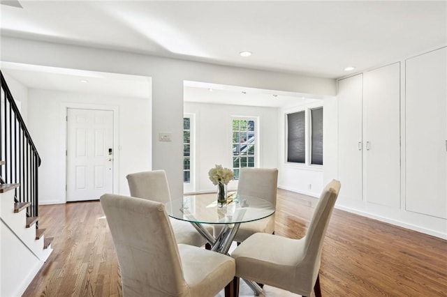 dining area with light wood-type flooring, stairs, and recessed lighting