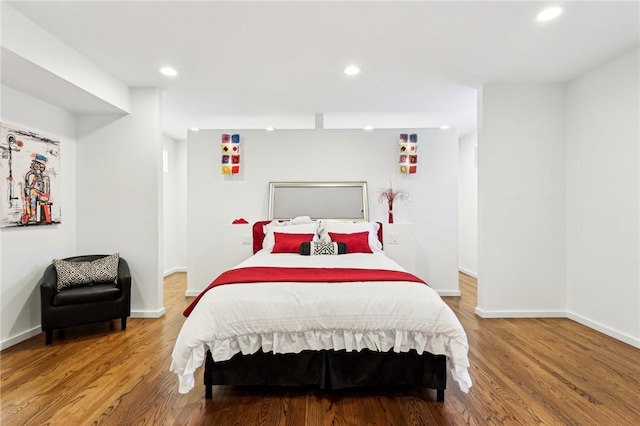 bedroom with wood finished floors, baseboards, and recessed lighting