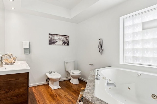 full bathroom featuring a jetted tub, a bidet, toilet, wood finished floors, and vanity