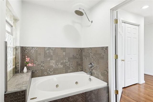 bathroom featuring a whirlpool tub and wood finished floors