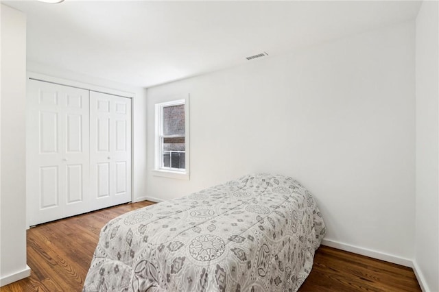 bedroom with baseboards, a closet, and wood finished floors
