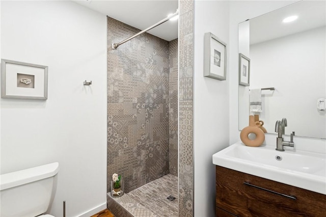 bathroom featuring toilet, walk in shower, vanity, and recessed lighting