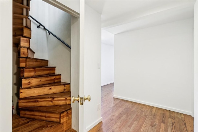 stairway featuring wood finished floors and baseboards
