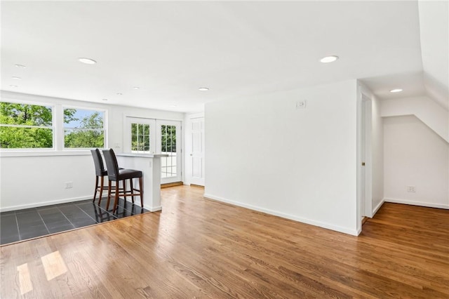 living room with wood finished floors, baseboards, recessed lighting, vaulted ceiling, and french doors