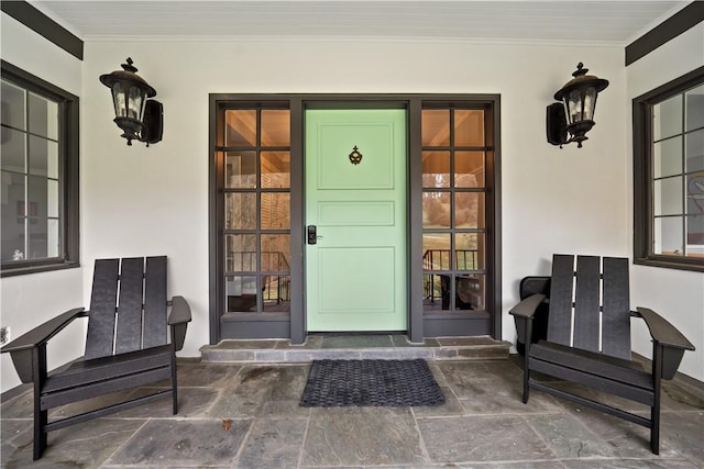 view of exterior entry featuring stucco siding and covered porch