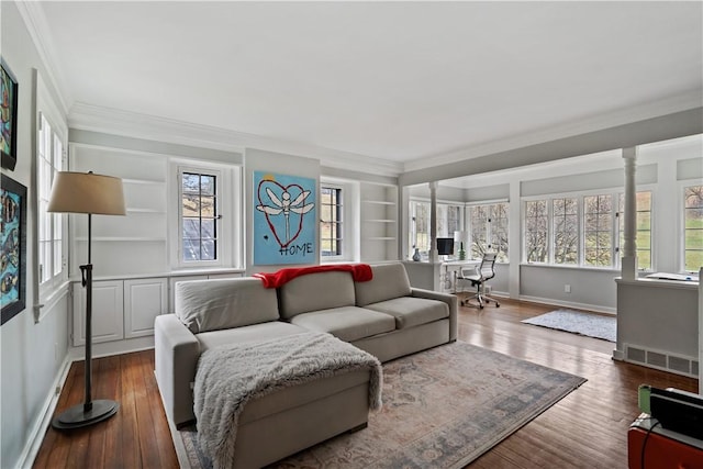 living area with crown molding, wood finished floors, baseboards, an office area, and built in shelves