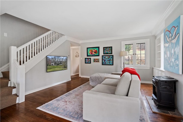 living area featuring stairs, wood finished floors, ornamental molding, baseboards, and a wood stove