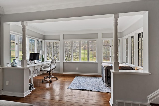 office space featuring hardwood / wood-style floors, crown molding, decorative columns, and baseboards