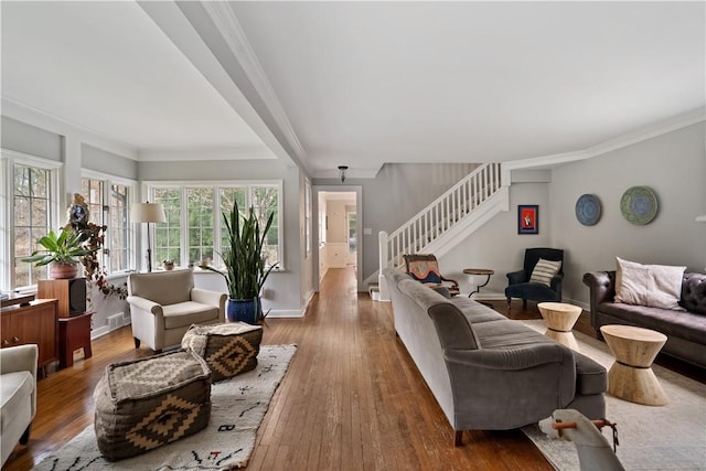 living room with stairway, hardwood / wood-style floors, crown molding, and baseboards
