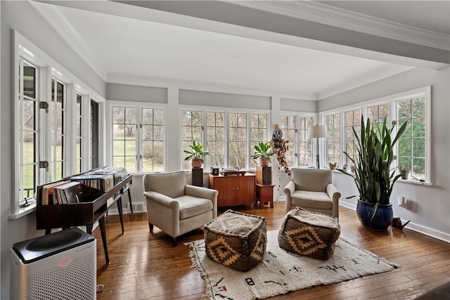 sunroom / solarium with french doors, hardwood / wood-style flooring, healthy amount of natural light, and crown molding