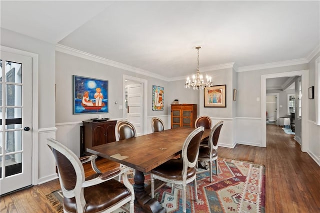 dining space with a chandelier, wood-type flooring, and crown molding
