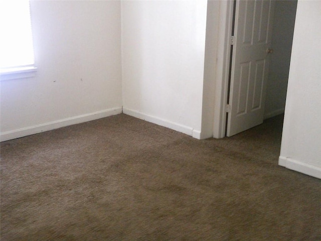 spare room featuring carpet flooring and baseboards