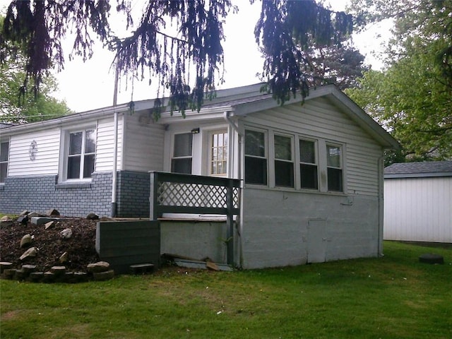 view of side of property with a yard and brick siding