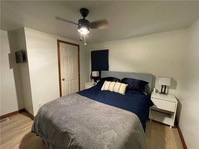 bedroom featuring light wood finished floors, baseboards, and a ceiling fan